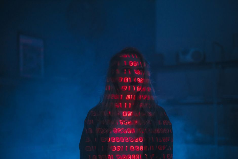 The image displays a close-up of a computer screen showing lines of code written in a programming language, featuring syntax highlighting with colors including blue, green, yellow, orange, and red. Th